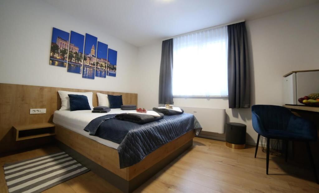 RoomSB guest room in Slavonski Brod with a queen bed and wooden floor